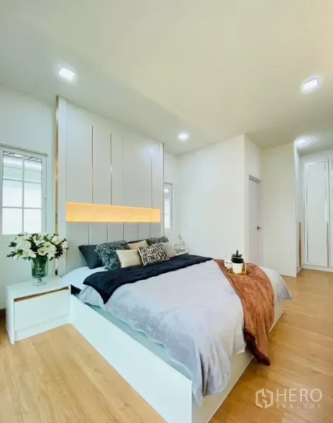 独立式住宅 出租在Prawet, Bangkok - 卧室宽敞一角，可见嵌入式衣柜、木地板与洁白墙面。