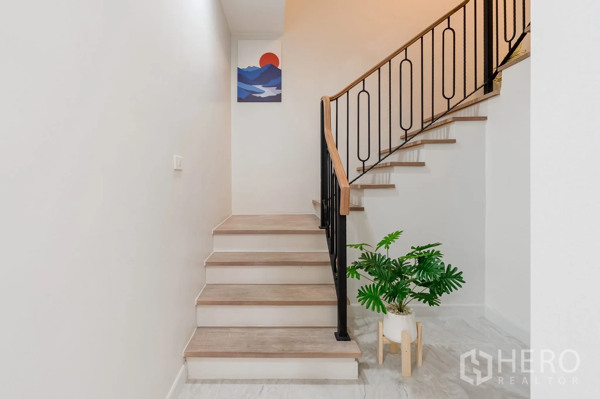 Home Office for rent in Khlong Toei, Bangkok - Lower stair landing with potted plant and iron railing.