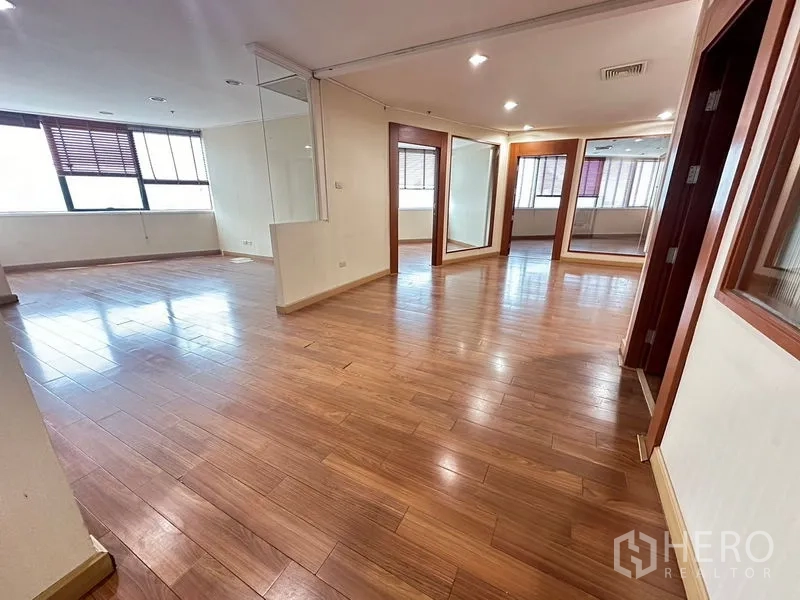 สำนักงาน ให้เช่า - ออฟฟิศโอเพนสเปซกว้าง พื้นไม้ ไฟดาวน์ไลต์ พร้อมผนังกระจกมุมใกล้หน้าต่าง