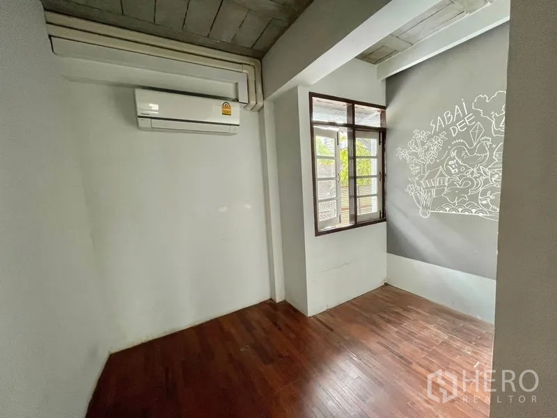 店屋 出租在Pathum Wan, Bangkok - 小型房间，木地板，可开启窗户，配有空调与装饰壁画。