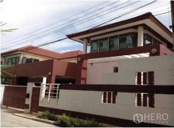 带办公室的家 出租在Khlong Toei, Bangkok - 现代两层住宅，高围墙与红棕色外立面。