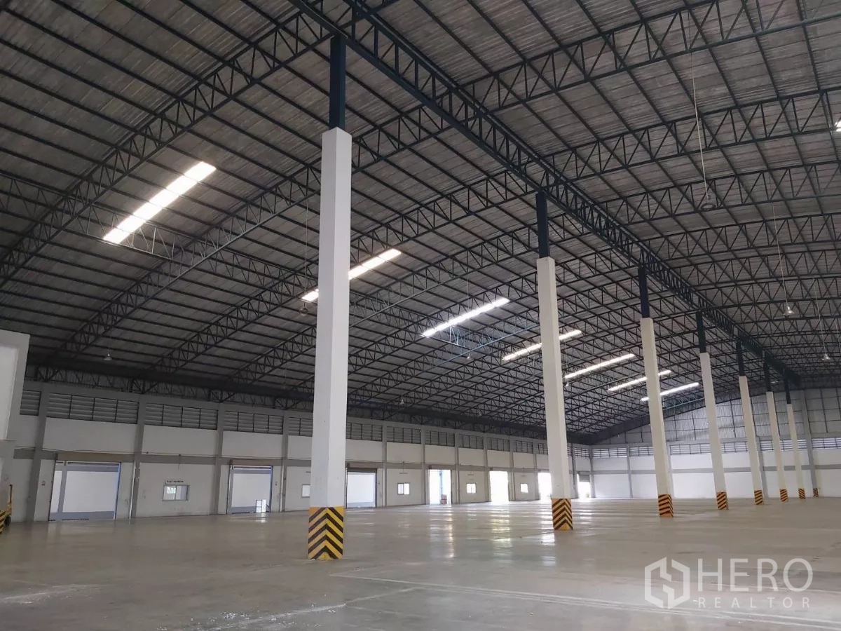 Warehouse for rent in Bang Bo, Samut Prakan - Close-up of aligned columns and multiple dock doors inside the warehouse.