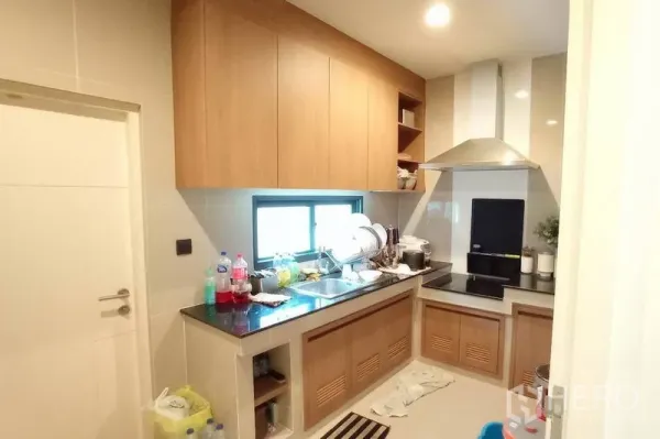 独立式住宅 出租在Bang Kapi, Bangkok - 开放式厨房，木质橱柜、石材台面、电磁炉与抽油烟机。