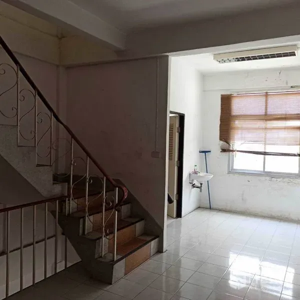 Shophouse for rent in Khlong Toei, Bangkok - Internal staircase with metal railing beside a small area with window and sink.