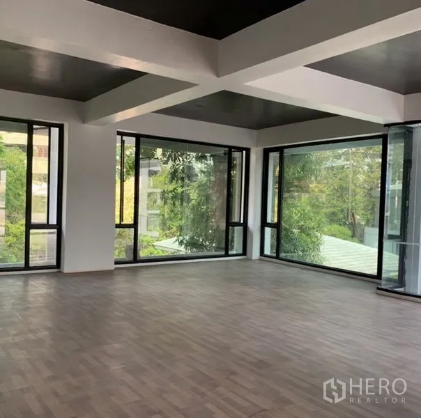 Standalone for rent in Khlong Toei, Bangkok - Corner upper floor with panoramic windows and wood flooring, ideal for office, showroom, or studio.
