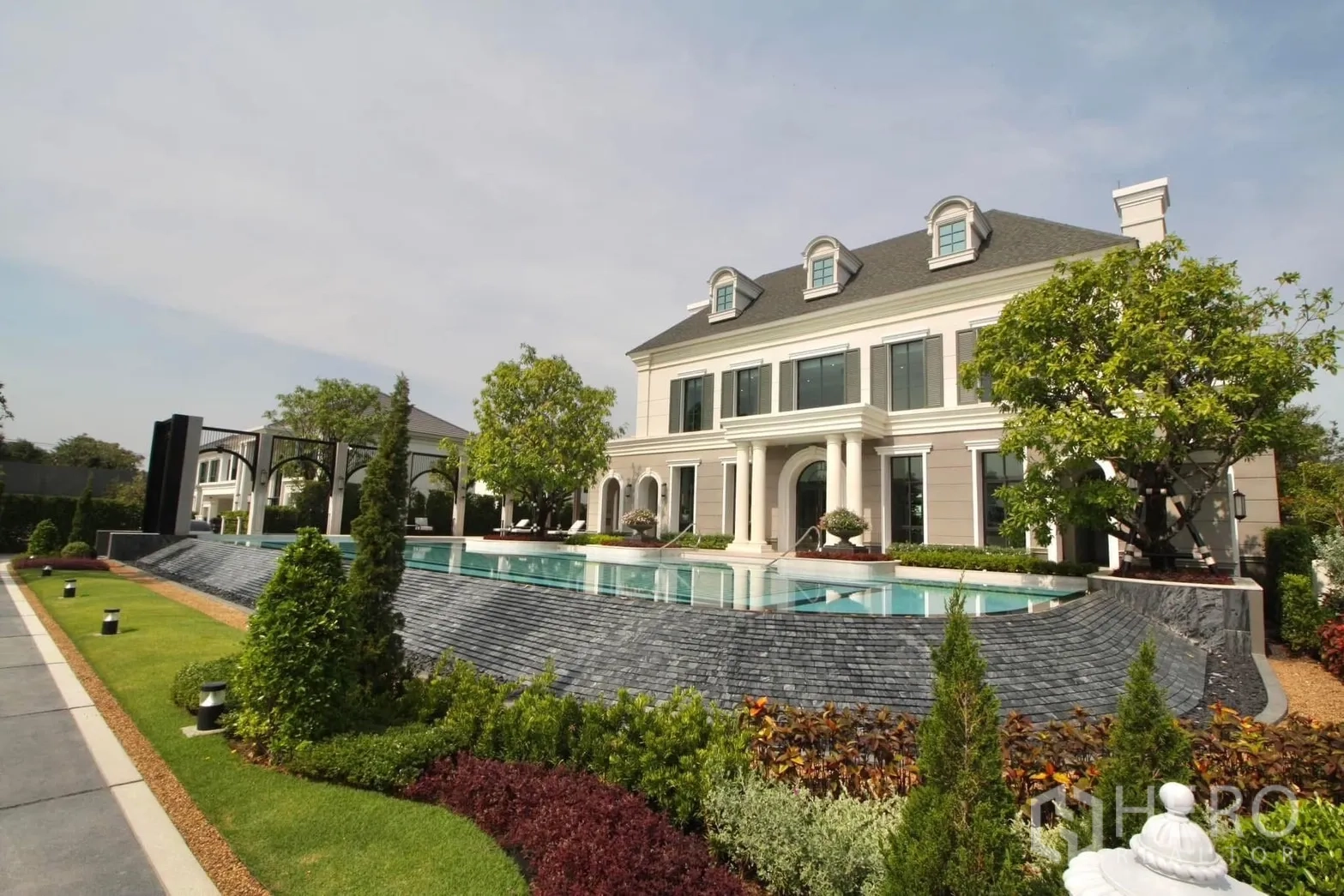 Detached House for rent in Bang Phli, Samut Prakan - Elegant clubhouse with colonial-style facade overlooking a resort-style swimming pool.