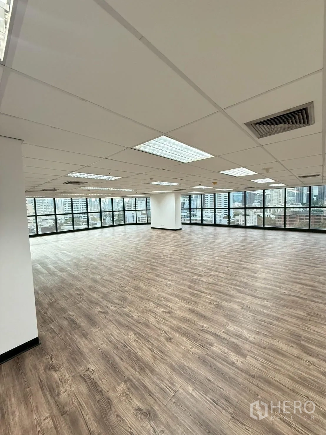 Office Space for rent in Watthana, Bangkok - Close view of wood-look vinyl flooring inside the empty office with window walls.