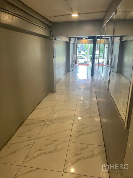 零售空间 出租在Khlong Toei, Bangkok - 采光良好的走廊，通向面向街道的玻璃入口。