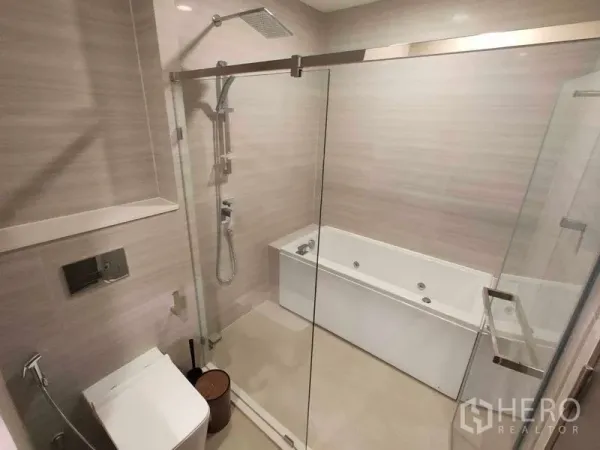 Condominium for rent in Watthana, Bangkok - Tiled bathroom featuring a glass-enclosed shower and a separate bathtub.