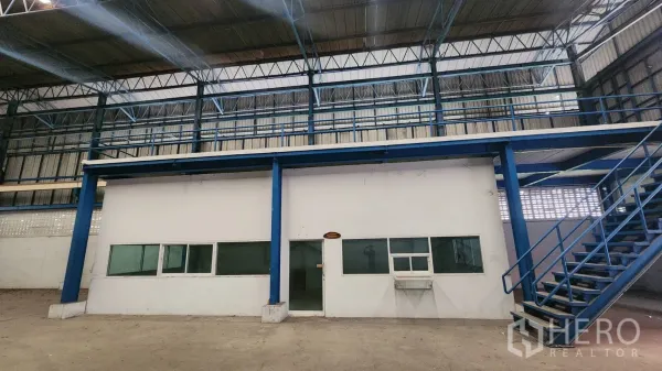 Warehouse for rent in Mueang Samut Prakan, Samut Prakan - Internal office block with windows and an external metal staircase inside the warehouse.