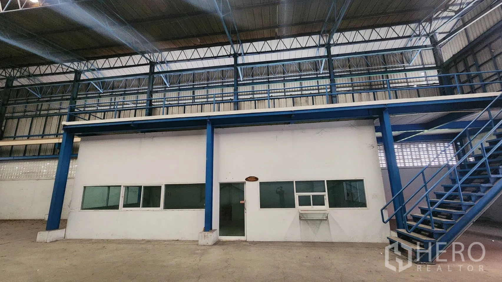 Warehouse for rent in Mueang Samut Prakan, Samut Prakan - Internal office block with windows and an external metal staircase inside the warehouse.