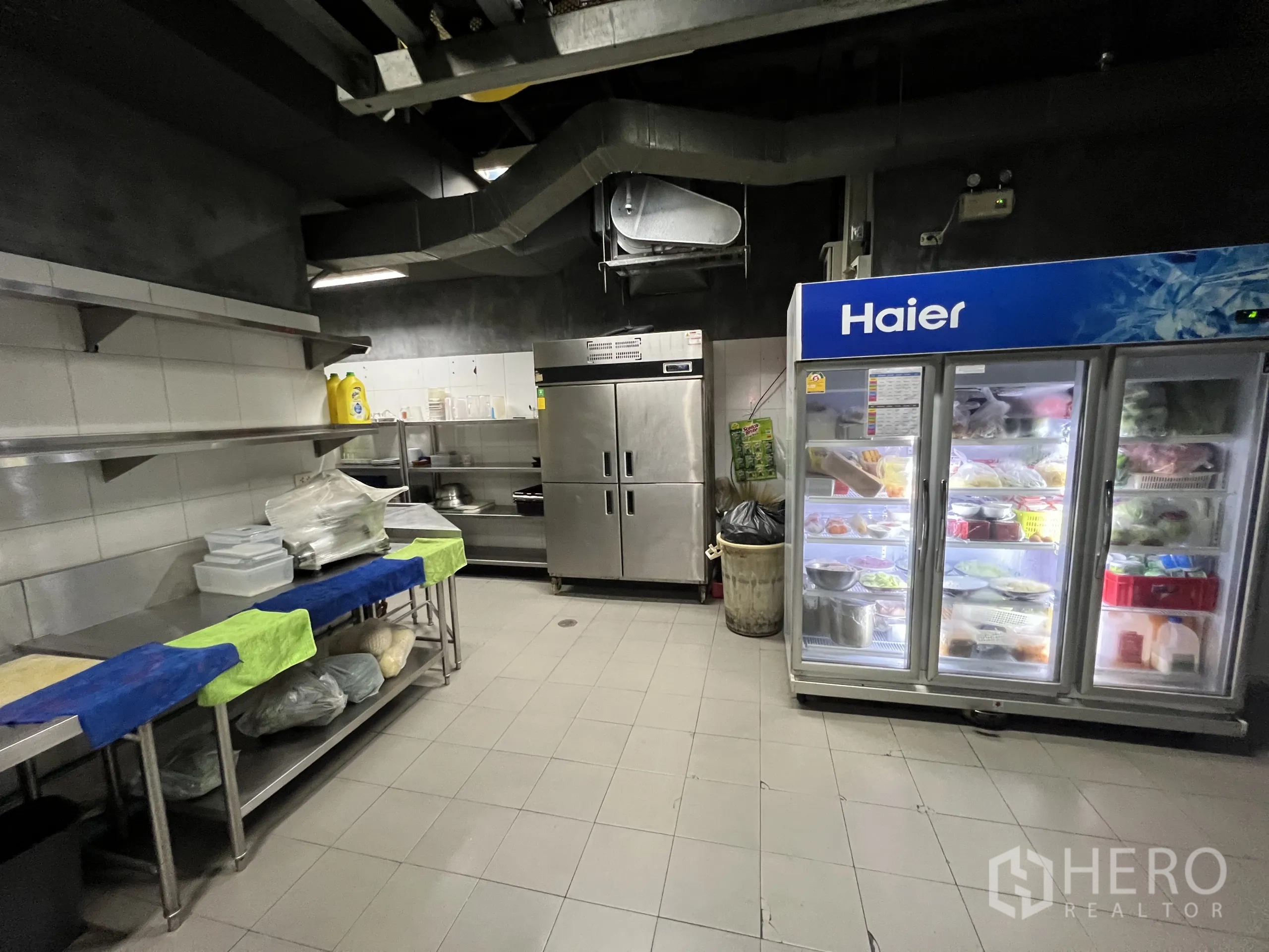 Retail Space for rent in Watthana, Bangkok - Catering kitchen with large refrigerators, prep tables, and overhead ventilation.
