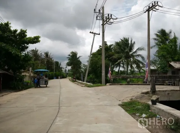 โรงงาน ให้เช่าหรือขายในKrathum Baen, Samut Sakhon - ถนนท้องถิ่นเงียบสงบ มีเสาไฟฟ้าและสะพานข้ามคลอง ท่ามกลางต้นไม้เขียวขจี