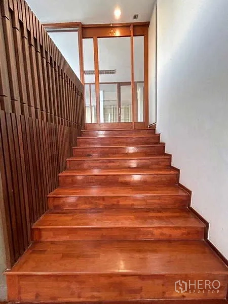 Home Office for rent or sale in Bang Phli, Samut Prakan - Wide timber staircase leading up to glass doors and lit hallway.