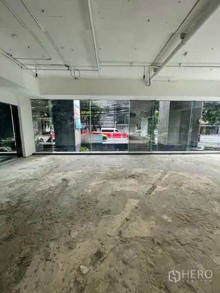 零售空间 出租在Watthana, Bangkok - 商铺内落地窗，面向街景与绿化带。