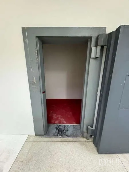 Standalone for rent in Khlong Toei, Bangkok - Small secure vault room behind thick steel door with red floor.
