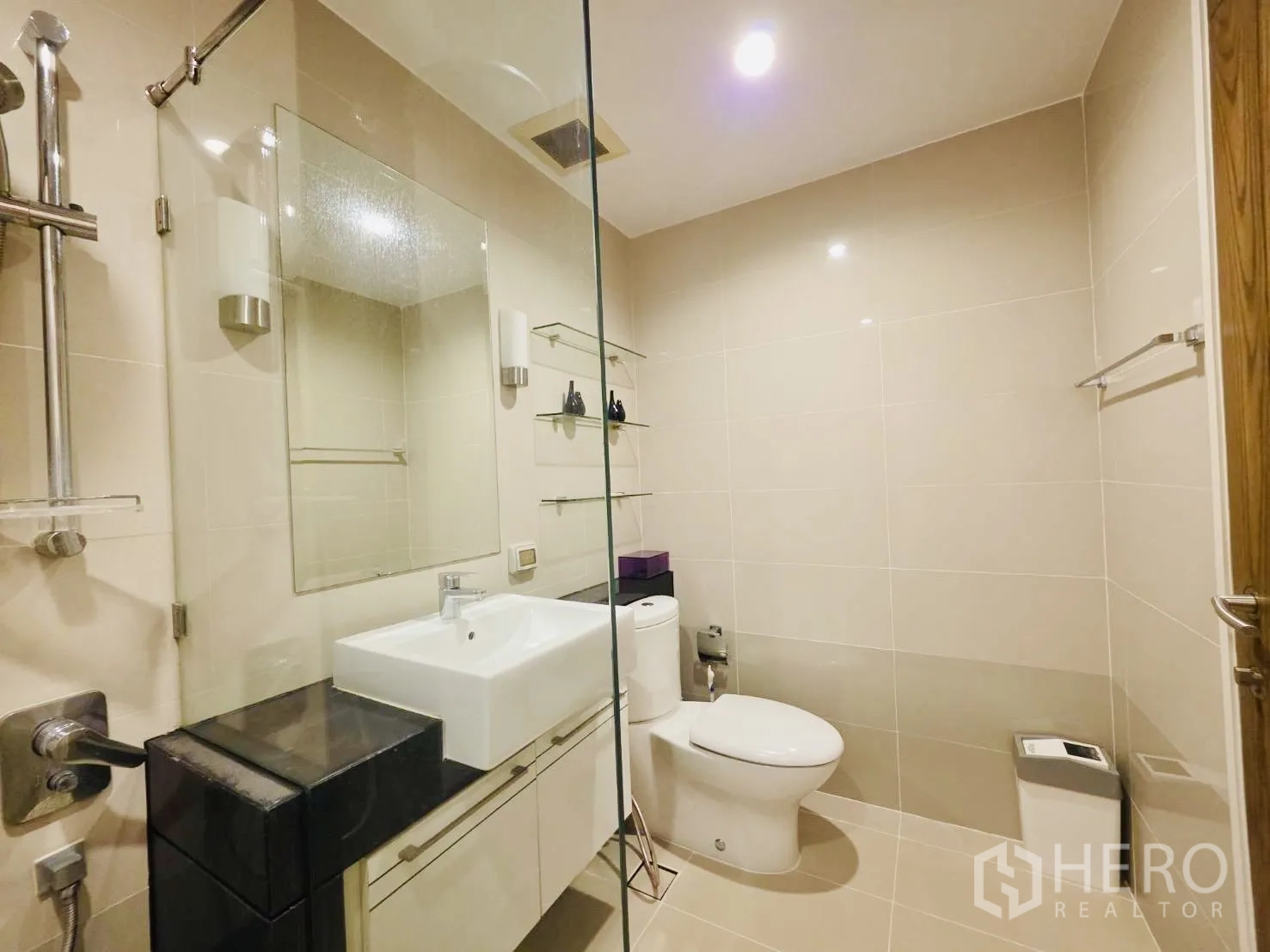 คอนโด for rent in Huai Khwang, Bangkok - ห้องน้ำสะอาดพร้อมฉากกั้นกระจก โถสุขภัณฑ์ ชั้นวางของ และเคาน์เตอร์อ่างล้างหน้า