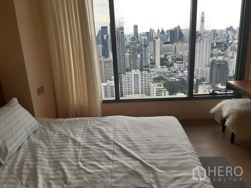 公寓 出租或出售在Watthana, Bangkok - 卧室配大床与落地窗，享受壮观城市景观。
