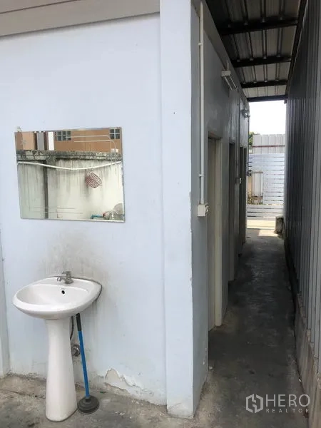货栈 出租在Don Mueang, Bangkok - 简易员工卫生间建筑，墙挂式洗手盆，位于仓库旁。