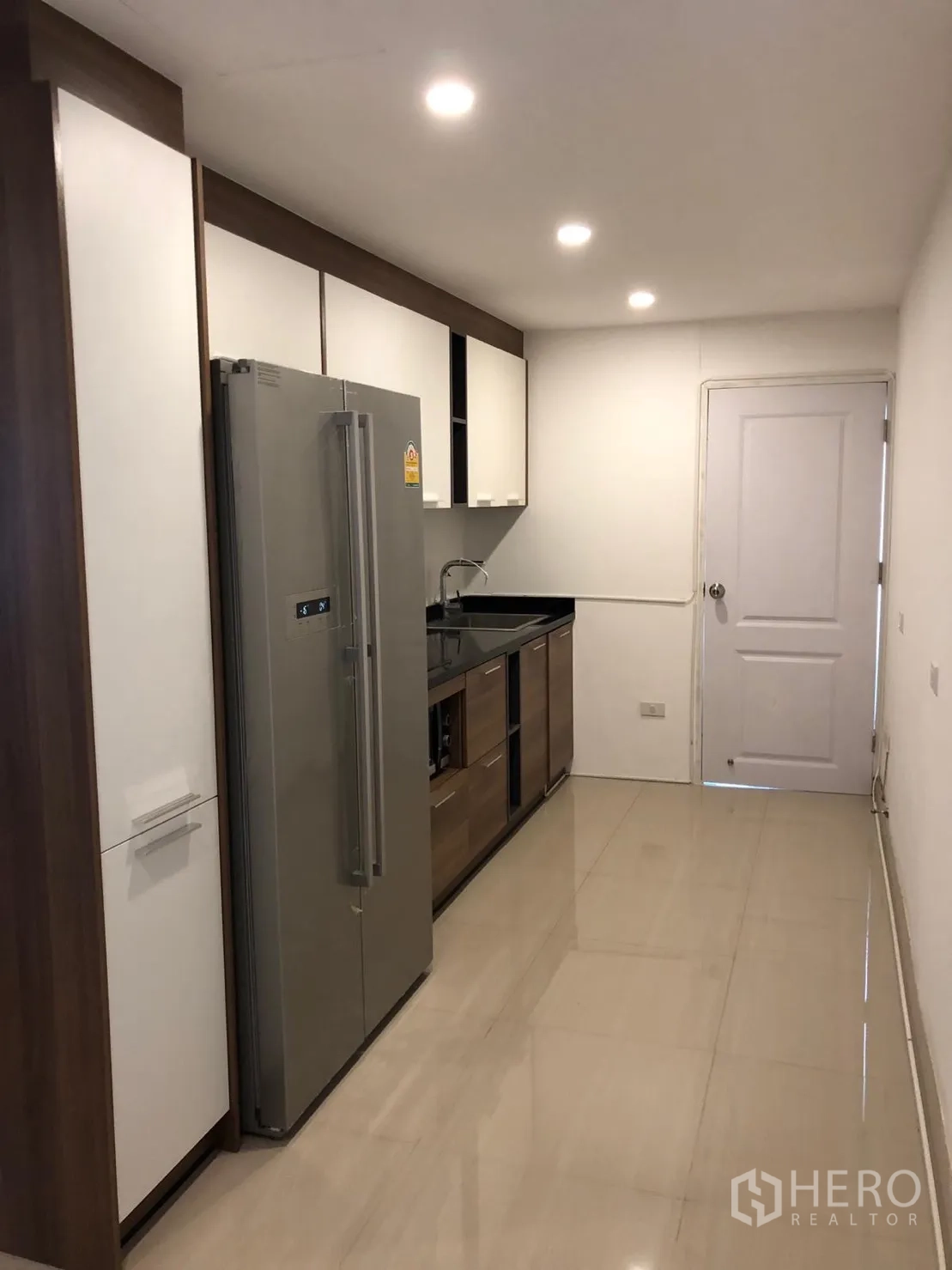 公寓 出租在Watthana, Bangkok - 走廊式厨房，大冰箱、吊柜、水槽与筒灯