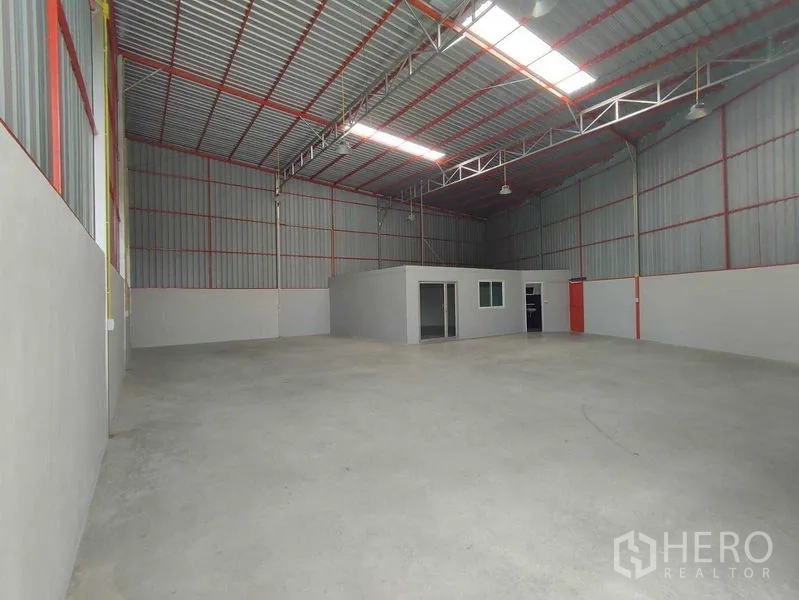 货栈 出租在Pak Kret, Nonthaburi - 宽敞仓库内部，采光天窗、钢结构桁架与平整混凝土地面。
