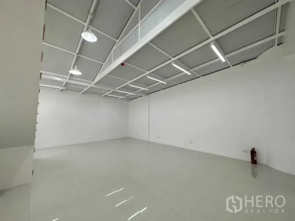 Office Space for rent or sale in Khlong Toei, Bangkok - Open-plan white office floor with glossy tiles, LED strip lights and a fire extinguisher.