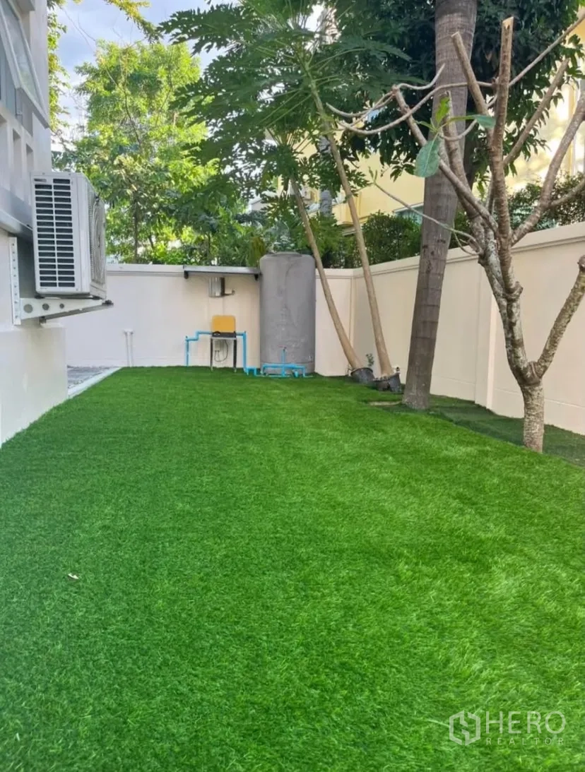 Detached House for rent or sale in Lat Phrao, Bangkok - Shaded rear garden with thick grass and boundary wall.