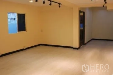 Office Space for rent in Bang Rak, Bangkok - Open-plan office area with pale flooring, track lighting, small window and doorway.
