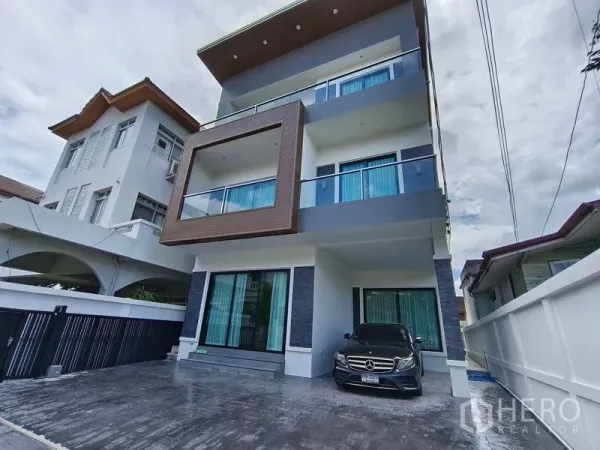บ้าน ให้เช่าหรือขาย - ภาพภายนอกบ้านเดี่ยว 3 ชั้นสมัยใหม่ มีระเบียง โรงจอดรถ และลานจอด