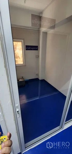 Warehouse for rent in Bueng Kum, Bangkok - Small room with window and sliding glass door, blue floor and white walls.