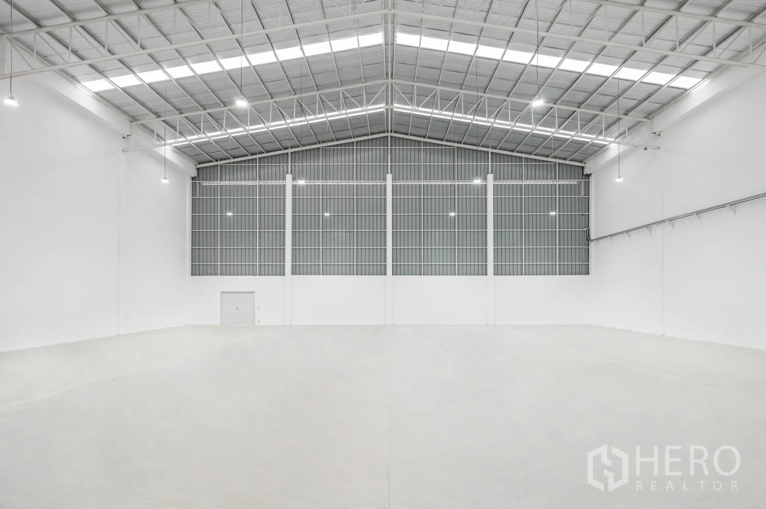 Factory for rent in Pathum Thani - Pristine high-bay warehouse with skylights and ventilated wall panels.
