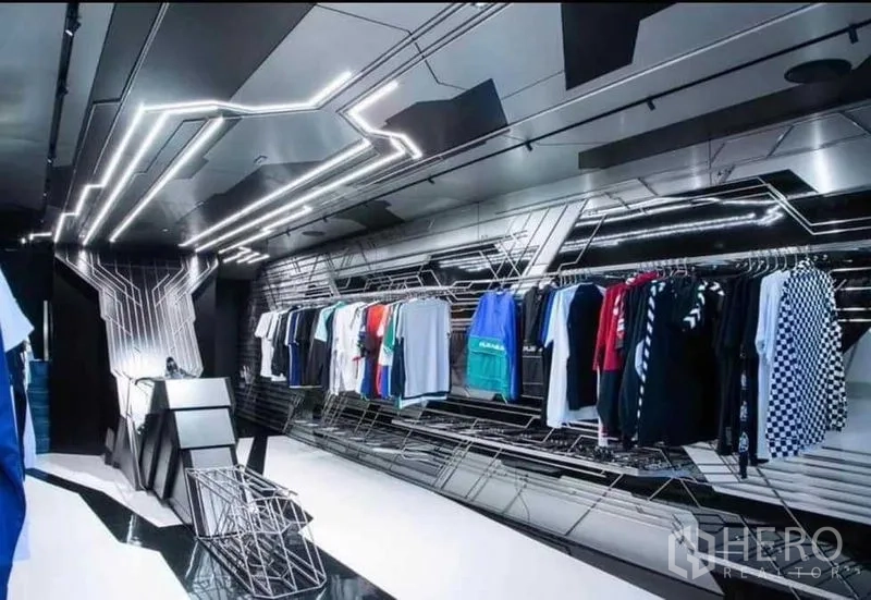 Shophouse for rent in Khlong Toei, Bangkok - Modern apparel zone with LED strip lighting and hanging clothing racks.