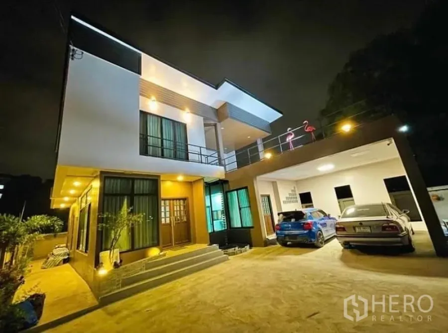 Detached House for sale in Sai Mai, Bangkok - Modern two-storey detached house at night with warm facade lighting and a covered carport.