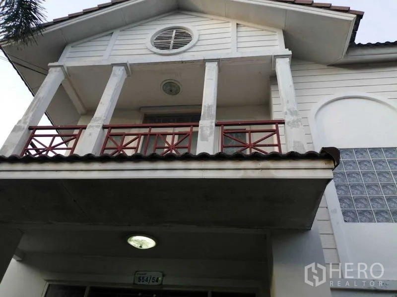 独立式住宅 出售在Prawet, Bangkok - 两层住宅的二楼阳台与山墙特写。