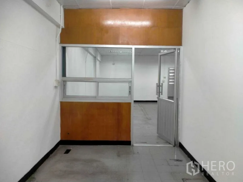 Warehouse for rent in Bang Phli, Samut Prakan - Compact internal office with sliding window and connecting door.