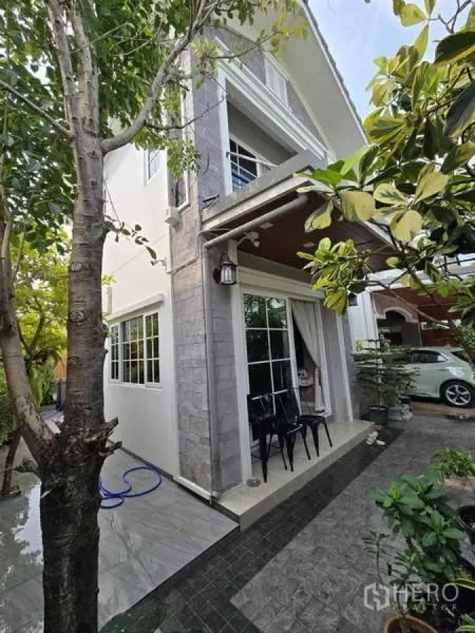 Detached House for rent in Thanyaburi, Pathum Thani - Another view of the two-storey exterior with patio and trees around the home.