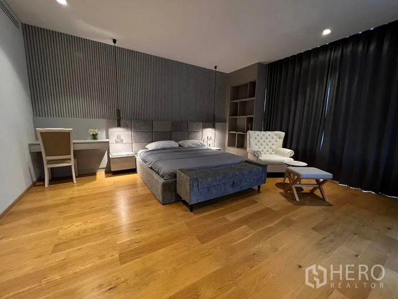 独立式住宅 出售在Suan Luang, Bangkok - 宽大卧室，软包床、扶手椅与木地板