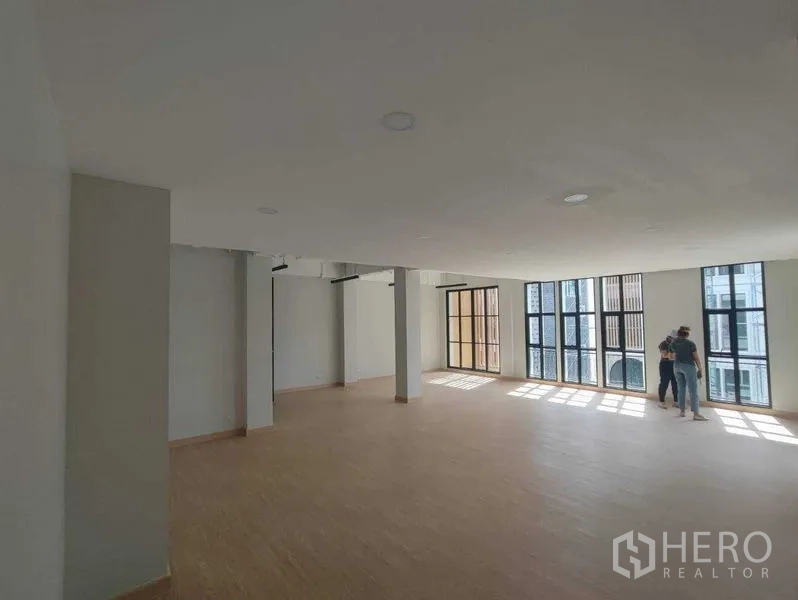 带办公室的家 出租在Bang Kapi, Bangkok - 采光充足的开放楼层，黑框大窗与木地板。