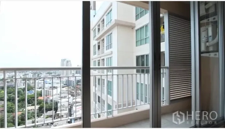 公寓 出租在Watthana, Bangkok - 带玻璃推拉门的阳台，眺望城市与邻近楼宇，临近BTS帕卡农站。