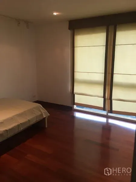 公寓 出租或出售在Watthana, Bangkok - 次卧带落地窗帘，木地板与柔和自然光。