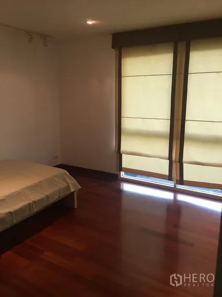 公寓 出租或出售在Watthana, Bangkok - 次卧带落地窗帘，木地板与柔和自然光。