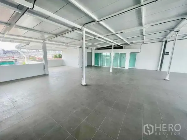 Home Office for rent or sale in Bang Kapi, Bangkok - Spacious open‑plan upper floor with tiled flooring, white steel beams, and sliding glass doors.