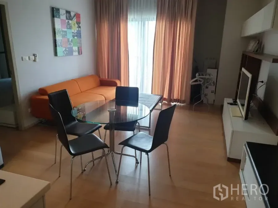 公寓 出租在Watthana, Bangkok - 明亮的客餐厅，橙色沙发、玻璃餐桌与落地窗帘，Ekkamai公寓室内。