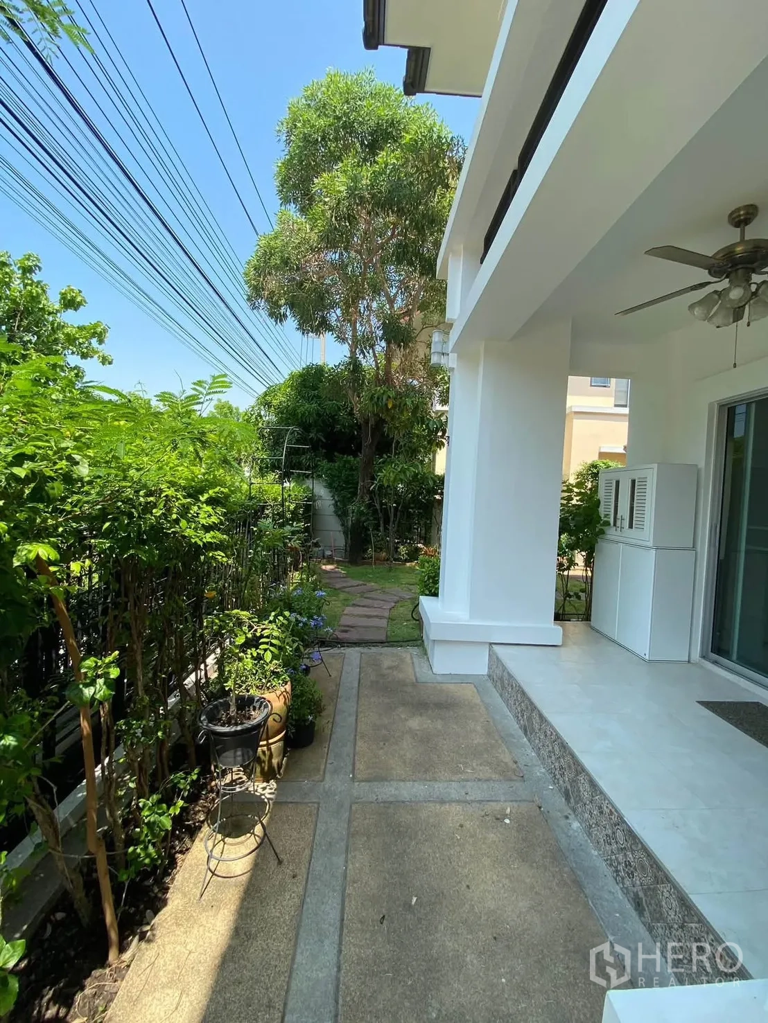 独栋房屋 for rent in Mueang Samut Prakan, Samut Prakan - 侧边有遮荫步道与绿植的露台空间。