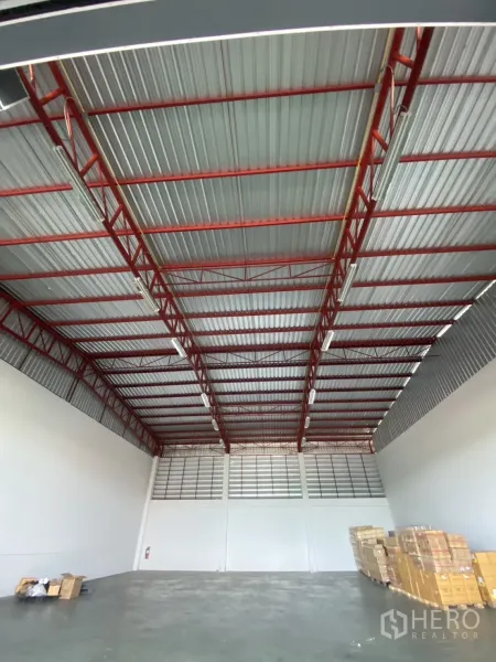 货栈 出租在Lat Krabang, Bangkok - 仓库内部高挑空间，红色钢桁架、白色墙面与混凝土地面