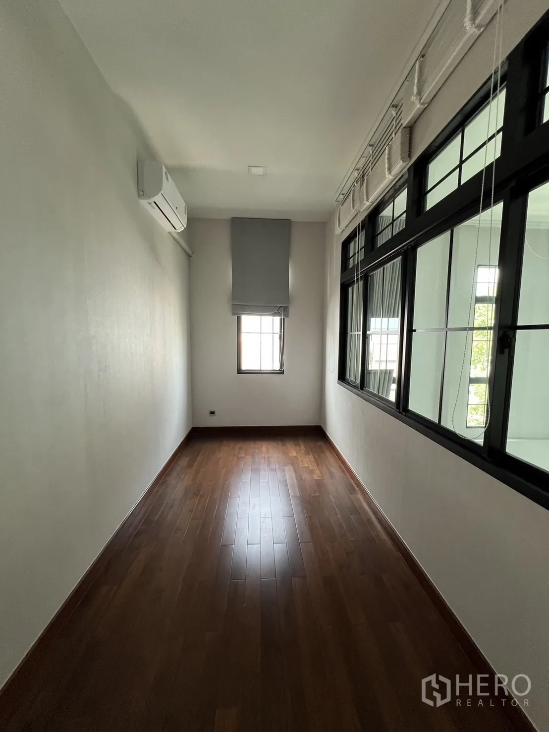 Detached House for rent or sale in Prawet, Bangkok - Narrow multipurpose room with wood floors and windows.
