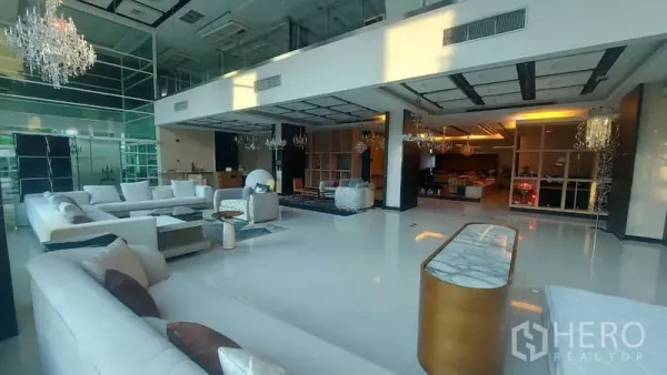 零售空间 出租在Watthana, Bangkok - 挑高双层大堂，白色沙发与水晶吊灯，整面玻璃墙