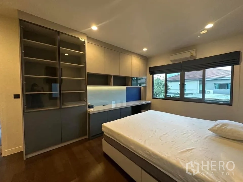 Detached House for rent in Bang Kapi, Bangkok - Bedroom with built-in wardrobe, study desk and large window.
