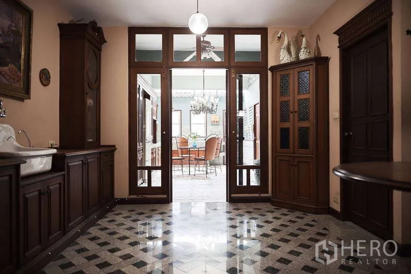 联排别墅 出租在Khlong Toei, Bangkok - 走廊望向厨房，玻璃门与木柜相映