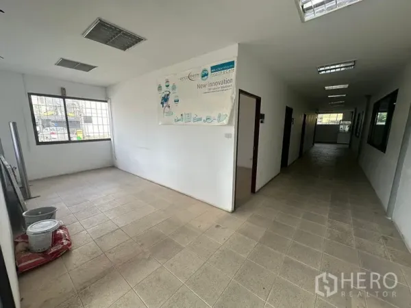 Warehouse for rent in Suan Luang, Bangkok - Ground-floor office hallway with tiled floor and windowed rooms.